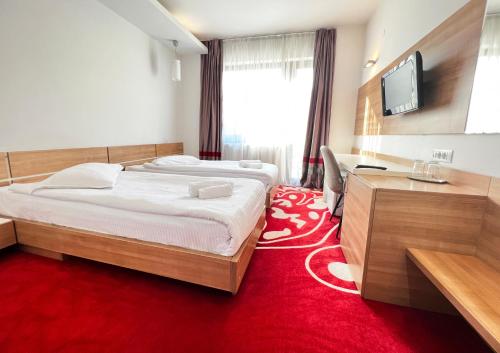 布拉索夫Hotel Ave Lux的一间卧室配有一张大床和红地毯