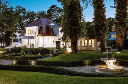 巴特萨罗皮斯库夫Villa Contessa - Luxury Spa Hotels的院子中间有喷泉的房子