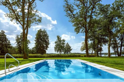 巴特萨罗皮斯库夫Villa Contessa - Luxury Spa Hotels的一座树木繁茂的庭院内的游泳池