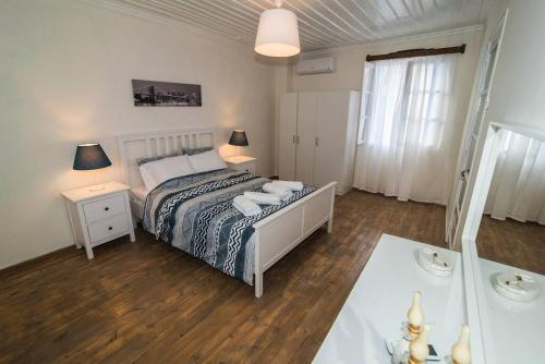 帕诺尔莫斯斯科派洛斯Avli Townhouse的一间卧室配有一张床和一张带两盏灯的桌子。