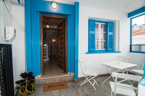 帕诺尔莫斯斯科派洛斯Avli Townhouse的一间拥有蓝色墙壁和桌椅的房间