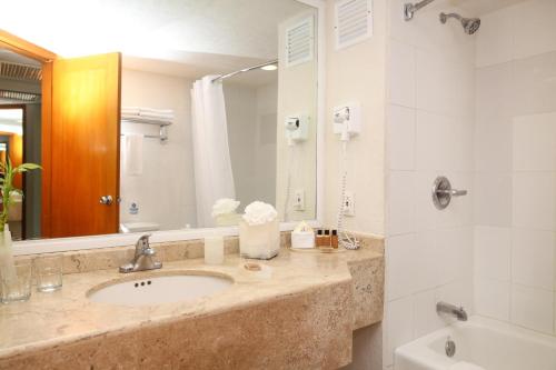 科苏梅尔墨西哥科苏梅尔之家的浴室配有盥洗盆、镜子和浴缸