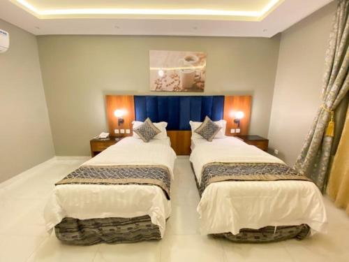 Abyār ‘Alīأزار للشقق الفندقية的配有2盏灯的酒店客房的2张床
