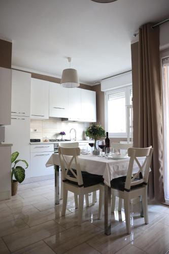 博洛尼亚A Casa Tua的白色的厨房配有白色的桌子和椅子