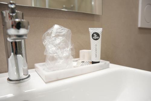 都灵Hotel Montevecchio的浴室盥洗盆配有牙刷和一盒牙膏