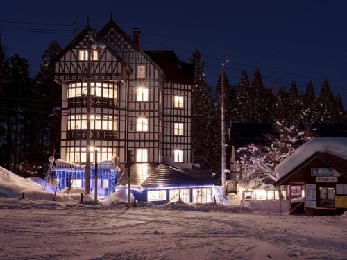 IidaHakuba Sun Valley Hotel Annex - Vacation STAY 90351v的一座大建筑,晚上有灯光,雪中