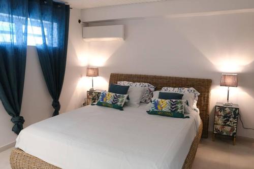 圣吕斯EBENE的卧室配有一张带蓝色窗帘的大型白色床