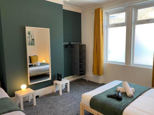 盖茨黑德Kitchener - Wonderful 2-Bedroom Apt Sleeps 5 Free Parking Free WiFi的一间卧室配有两张床和镜子
