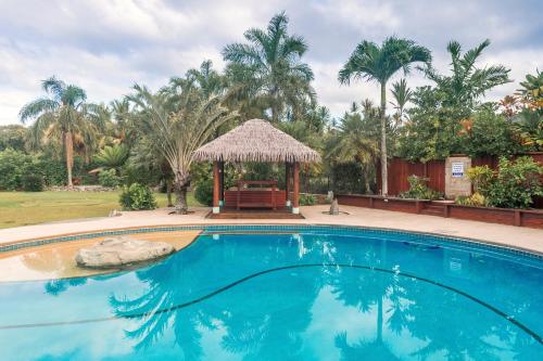 拉罗汤加GT拉罗汤加钓鱼山林小屋的一个带凉亭和棕榈树的游泳池