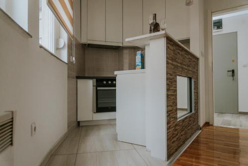 鲁马David 2的厨房配有白色橱柜和砖墙