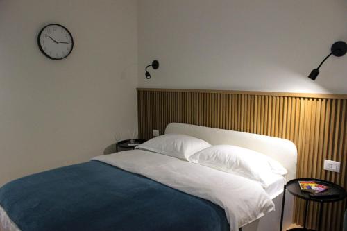 地拉那Studio in Tirana的卧室配有一张床,墙上挂着一个钟