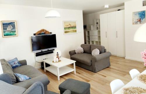 詹塔尔Apartament Morze Sztuki, Jantar的客厅配有两张沙发和一台电视机