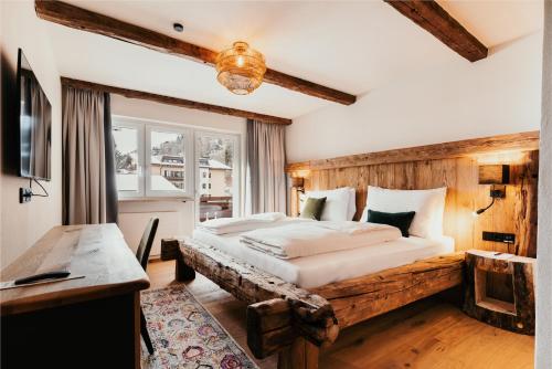 萨尔巴赫Dorfhotel Glücksschmiede的一间卧室配有一张大床和木制床头板
