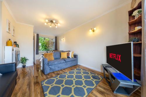 海维康Pierocks Carver Entire house, Hot tub & WIFI的客厅配有蓝色的沙发和电视