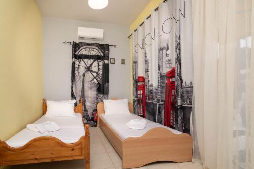 卡拉马孔Stergios House的宿舍间内的两张床和红色电话亭