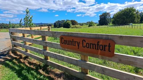 汉密尔顿Country Comfort的上面有乡村舒适标志的木栅栏