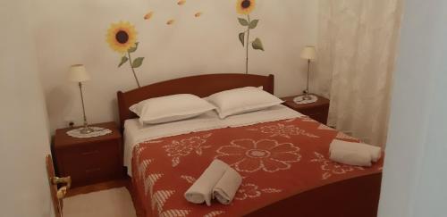 耶尔萨Apartman Bogdan的一间卧室配有一张带两张桌子和两盏灯的床。