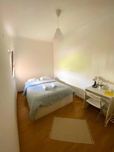 里斯本Lisbon Airport Guesthouse的一间卧室配有一张床、一张桌子和一张桌子以及一张书桌。