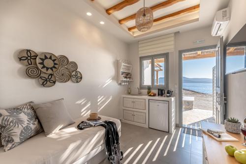 斯希努萨岛Porto Dema Luxury Suites的厨房以及带沙发和桌子的客厅。