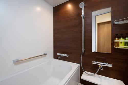 东京MYSTAYS 西新宿酒店的带浴缸、水槽和镜子的浴室