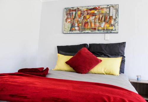 博克斯堡4 on Verbena的一间卧室配有红色和黄色枕头的床