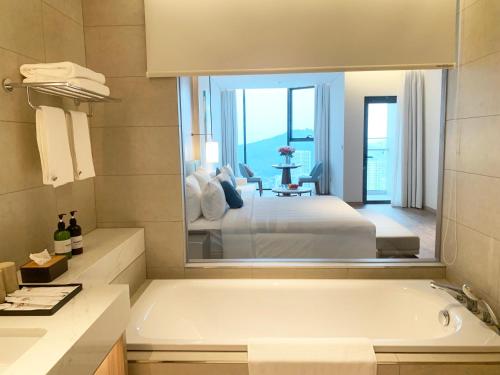 下龙湾HB Serviced Apartment - Alacarte Hạ Long的带浴缸的浴室和卧室