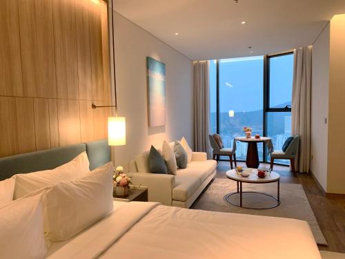 下龙湾HB Serviced Apartment - Alacarte Hạ Long的酒店客房设有床和客厅。