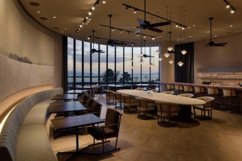 大津琵琶湖酒店的餐厅设有桌椅和大窗户。