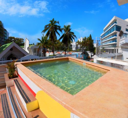 圣安德烈斯Hotel Nomadic Design的建筑物屋顶上的游泳池