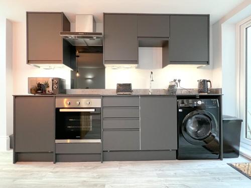 KentThe Bohemian Basement的厨房配有洗衣机和洗衣机。