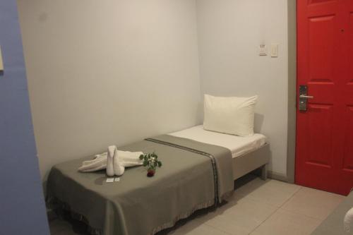 宿务ML SUITES CEBU的小房间,设有一张床和一扇红色的门