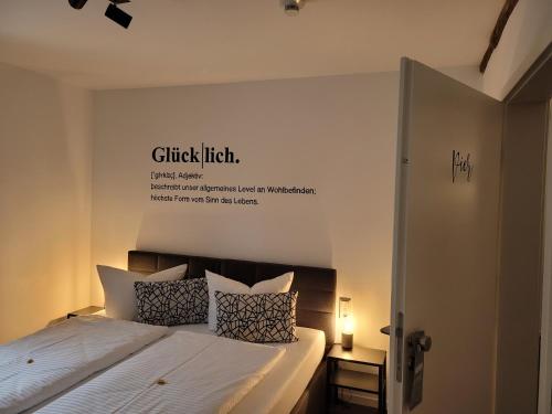 弗兰肯贝格Hotel Apartment Ferienwohnung Meyenhof Frankenberg Eder的卧室配有一张挂有墙上标志的床