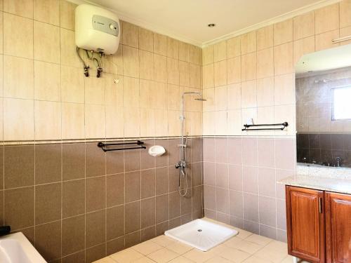 达累斯萨拉姆Jm Lodge - Kunduchi的带淋浴、卫生间和盥洗盆的浴室