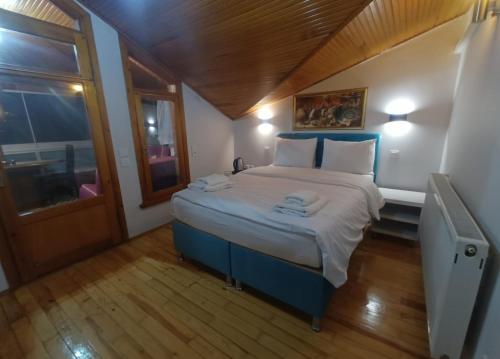 比于卡达Buyukada Cinar Hotel的一间小卧室,配有一张带白色床单的大床
