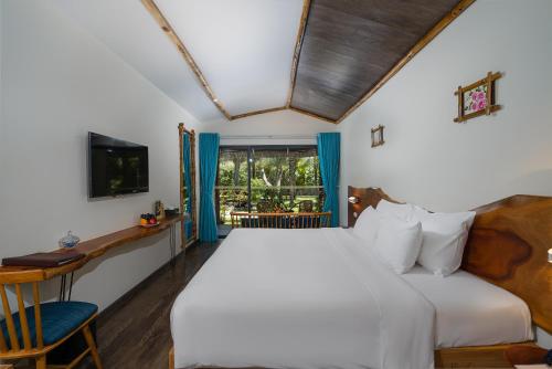 绥和市Sala Tuy Hoa Beach Hotel的一间卧室设有一张大床和一个窗户。