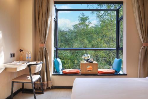 桂林象山璞云酒店(桂林两江四湖东西巷店)的卧室设有窗户、桌子和椅子