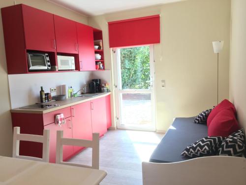 莱比锡die Senfbude - schöne, ebenerdige 2-Raum-Apartments mit Stellplatz und Terrasse的一间带红色橱柜的客厅和一间厨房
