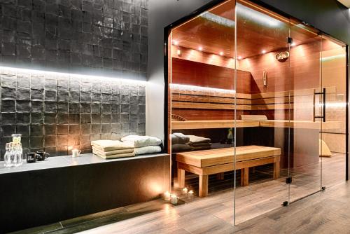 罗兹Hotel The Loom的浴室设有玻璃淋浴间、长凳和水槽