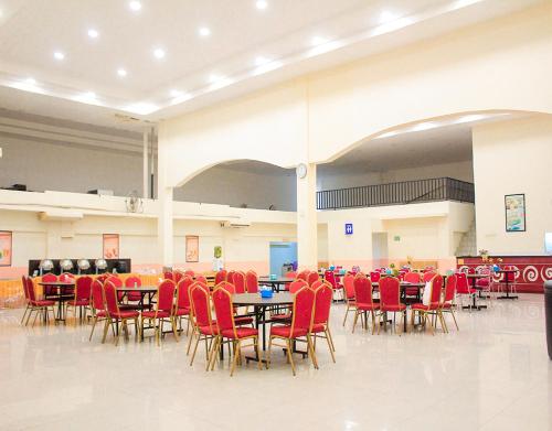 BagansinembahSuzuya Hotel Bagan Batu的大型客房配有桌子和红色椅子
