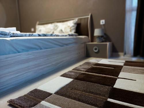 鲁塞Стоянови的一间卧室配有一张床,铺有一个 ⁇ 板地板