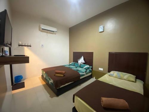 关丹TGL Aparthotel Tanjung Lumpur的一间带两张床和电视的小卧室