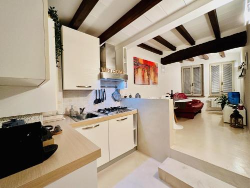 帕尔马New Street House的一间带白色橱柜的厨房和一间客厅