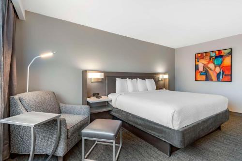洛克维尔Best Western Premier Rockville Hotel & Suites的配有一张床和一把椅子的酒店客房