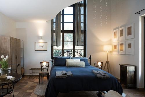 佩切图Casa Kiko Pecetto的一间卧室设有蓝色的床和大窗户