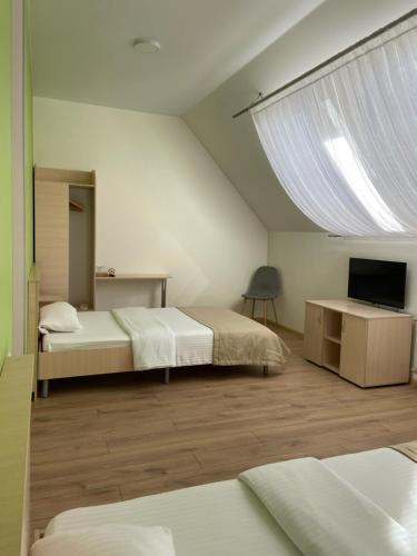 HadyachГотель Едем的一间卧室设有两张床、一台电视和一扇窗户。