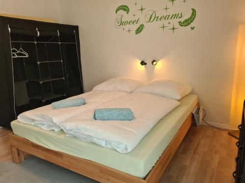 WaldbüttelbrunnLichtdurchflutetes Zimmer - Käppele的一张带两个枕头的床和一个读甜梦的标牌