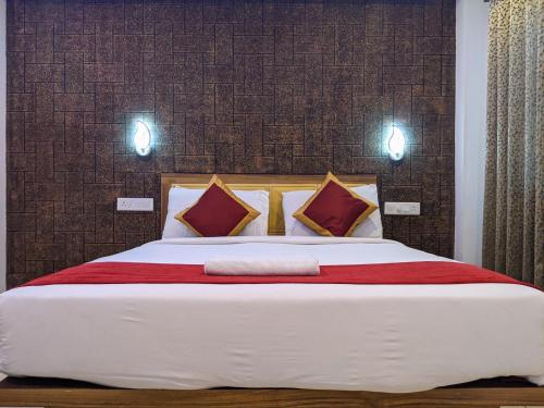 埃尔讷古勒姆Hotel Feathers的卧室配有一张大床,墙上有两盏灯