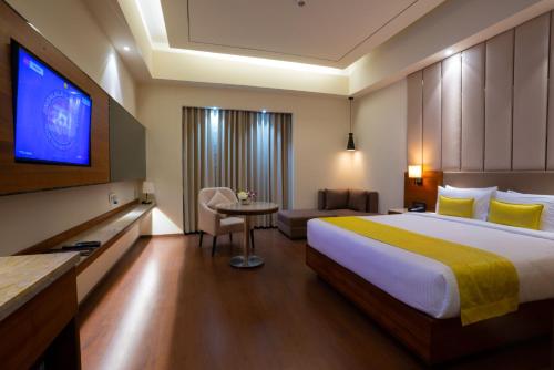 古瓦哈提Ratnamouli Palace的酒店客房设有一张大床和一台电视机。