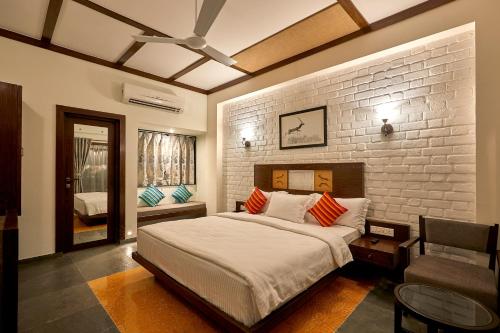 VelavadarBlackbuck Safari Lodge Velavadar的一间卧室设有一张大床和砖墙