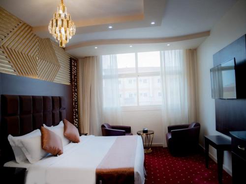 吉赞نزل السلطان للأجنجة الفندقية的酒店客房设有一张大床和吊灯。